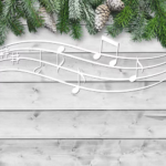 Musical notes drift across some wooden slats, which are topped with a frosted garland